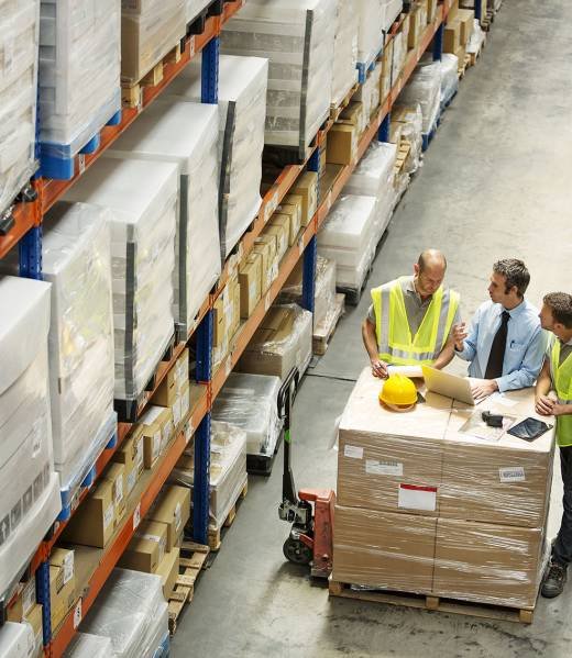 High angle view of supervisor discussing with workers at distribution warehouse