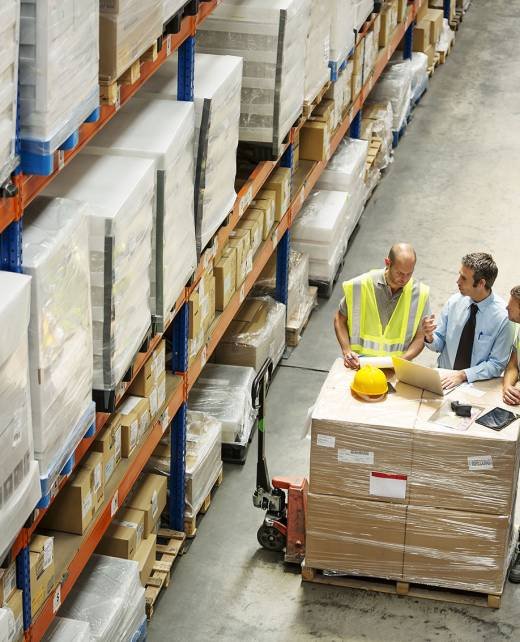 High angle view of supervisor discussing with workers at distribution warehouse